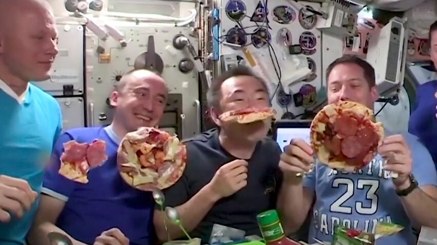 astronauti mangiano la pizza sulla stazione spaziale