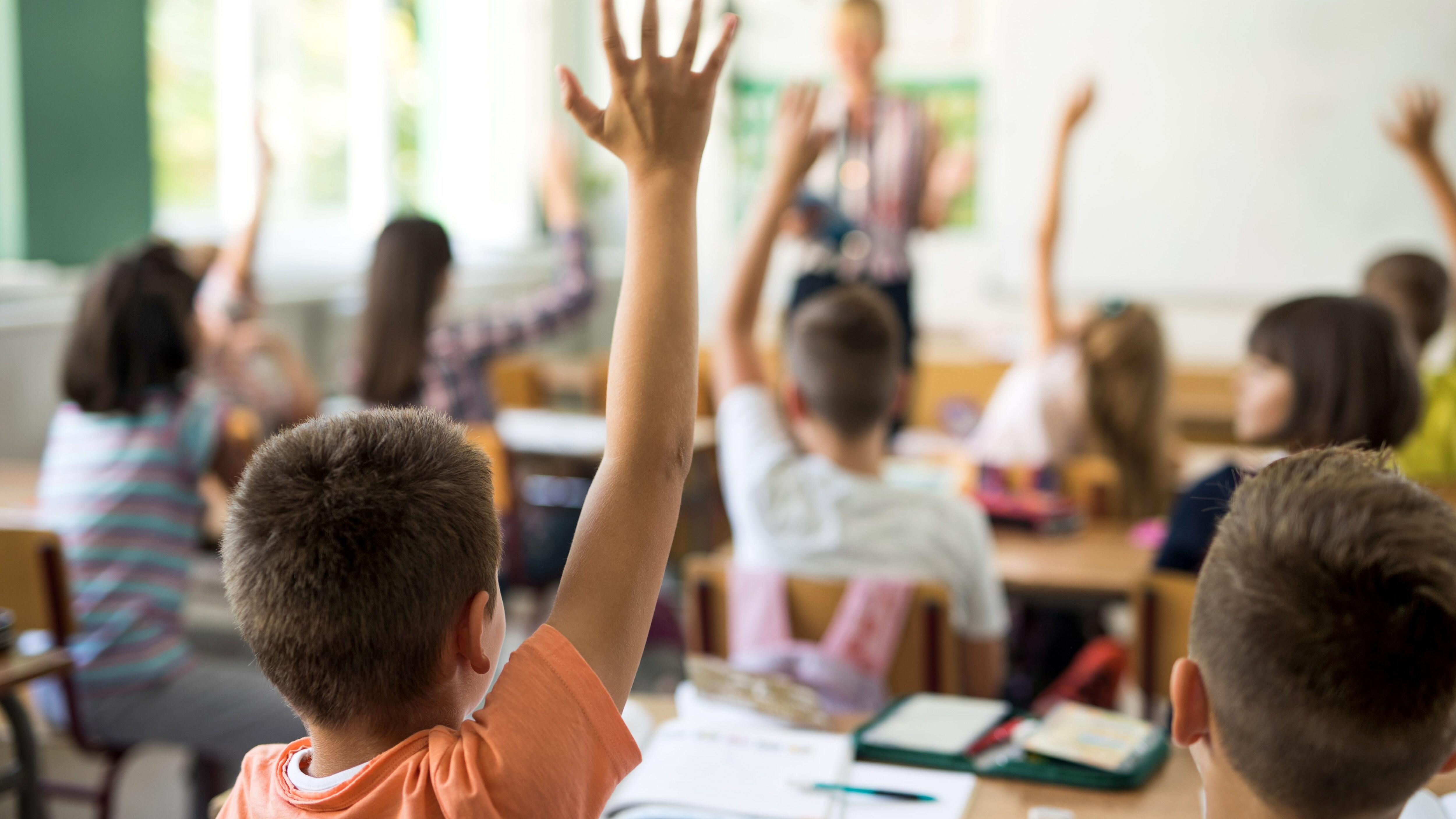 bambini a scuola mano alzata