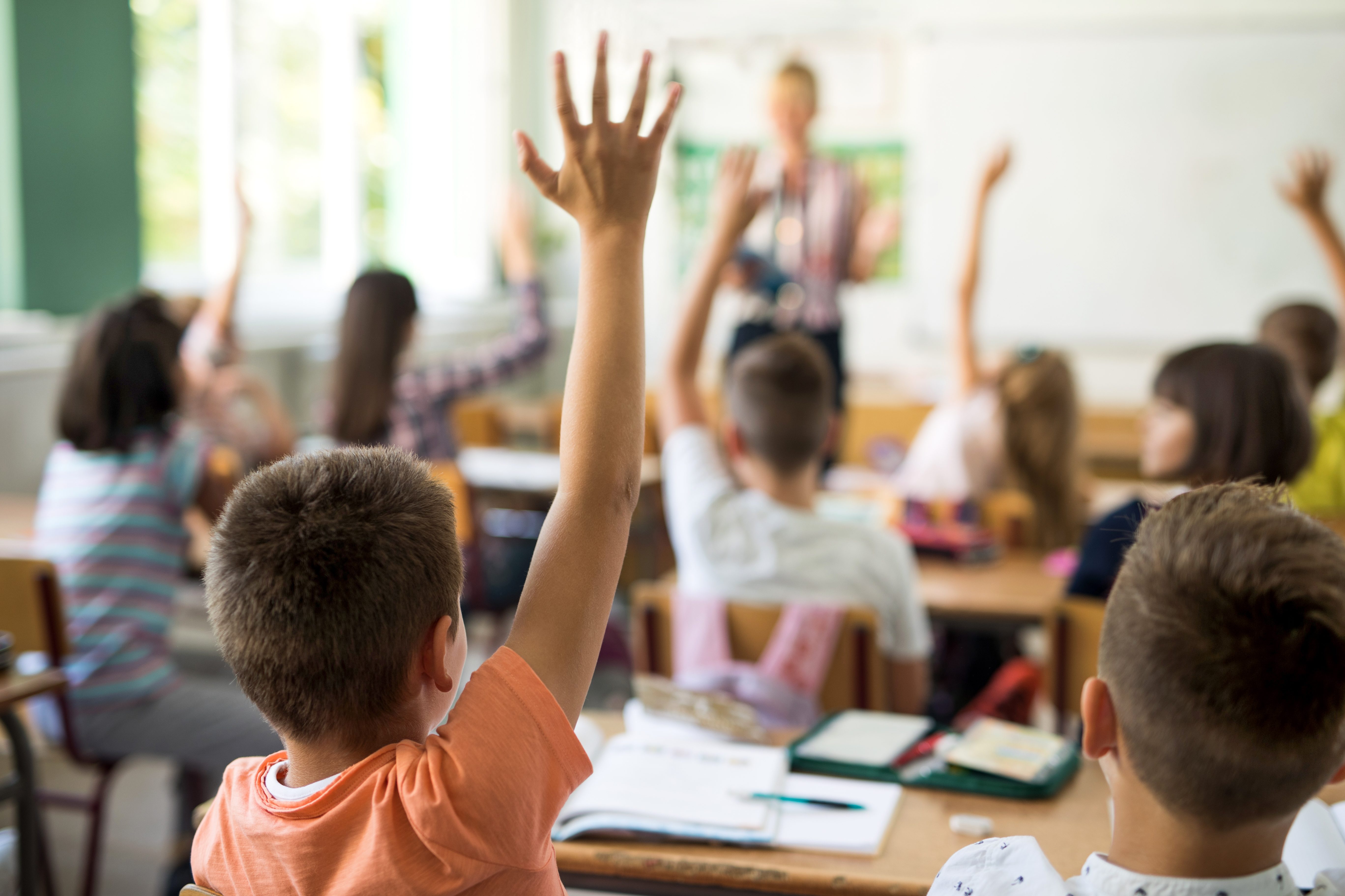 bambini a scuola mano alzata