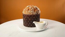 dolce lievitato accompagnato da ciotola di crema su un tavolo